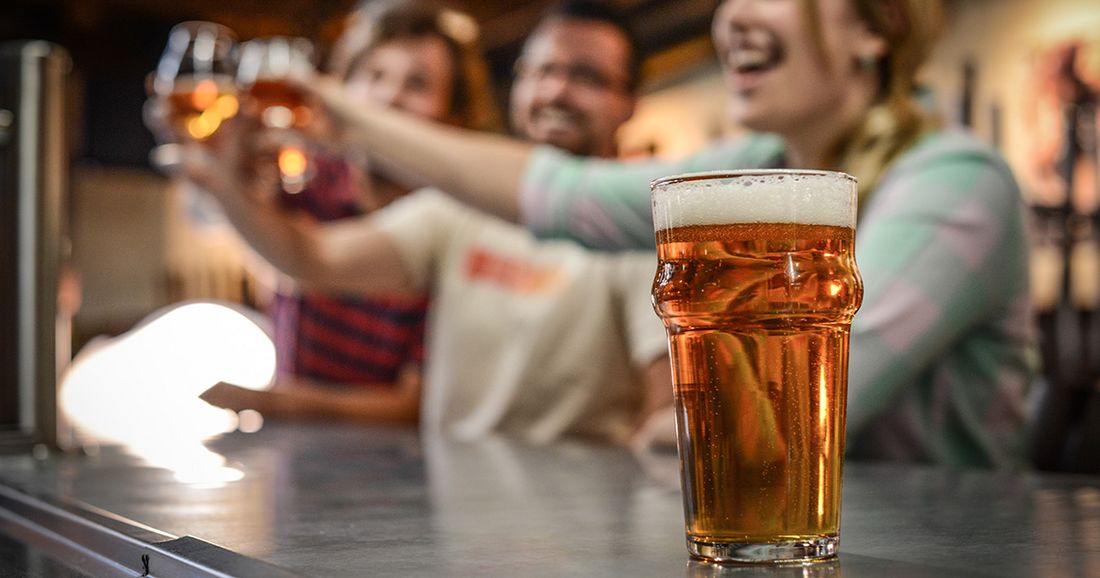 Northshore brewery bike tour with Brooks Bike Shop — friends raising glasses of craft beer at a taproom on the Tammany Trace