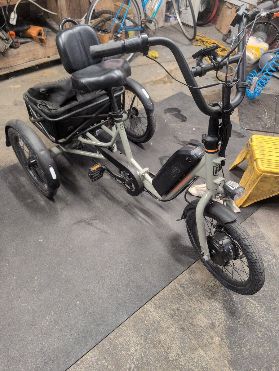 Rad Power Bikes RadTrike electric tricycle rental at Brooks Bike Shop — gray three-wheel e-trike with a backrest seat and a big rear cargo basket